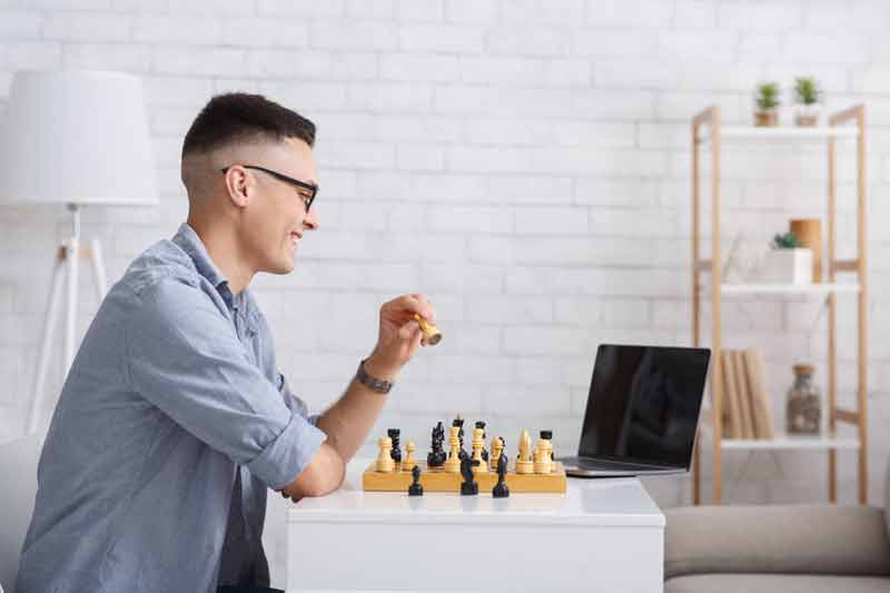 Man learning chess from online video