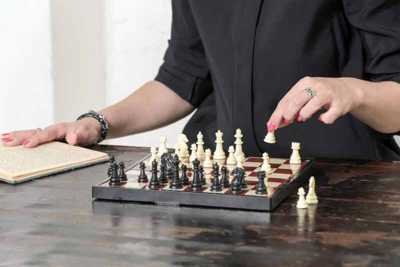 Woman practicing chess alone